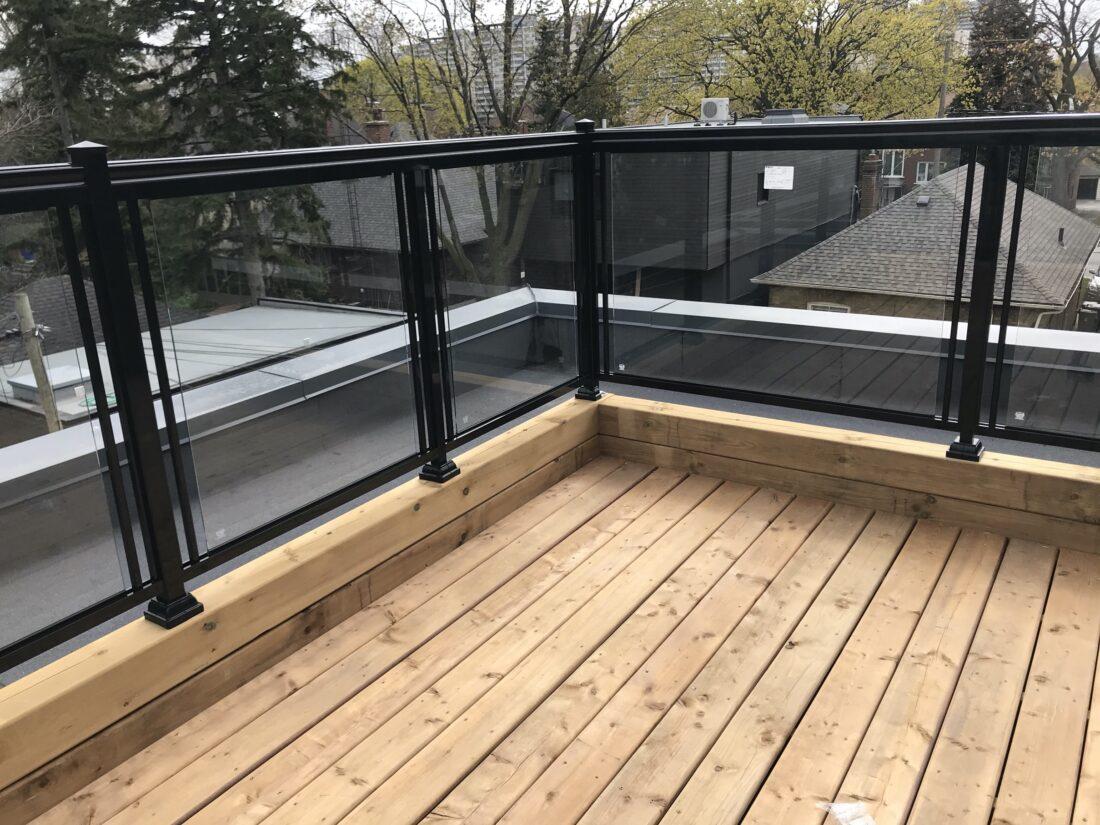 patio railing with black aluminum handrail and glass in toronto