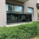 aluminum railing on a ground level balcony with super grey glass