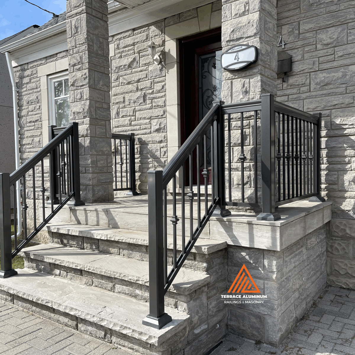 Black aluminum railings installed on a flagstone front porch in Oakville.