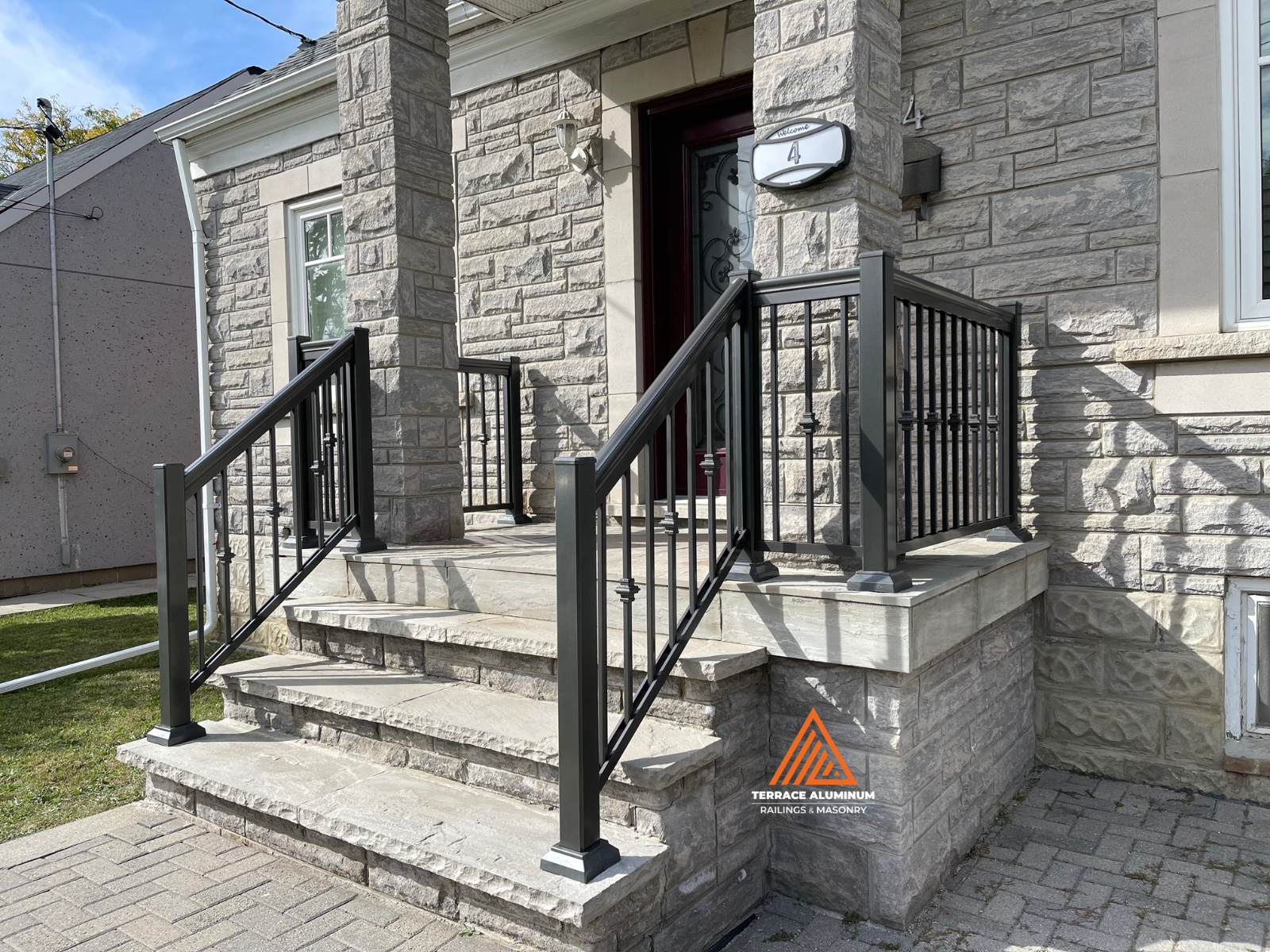 Black aluminum railings installed on a flagstone front porch in Oakville.