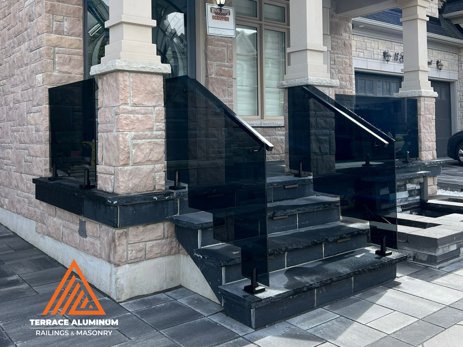 Oakville backyard with flagstone deck and frameless glass railing