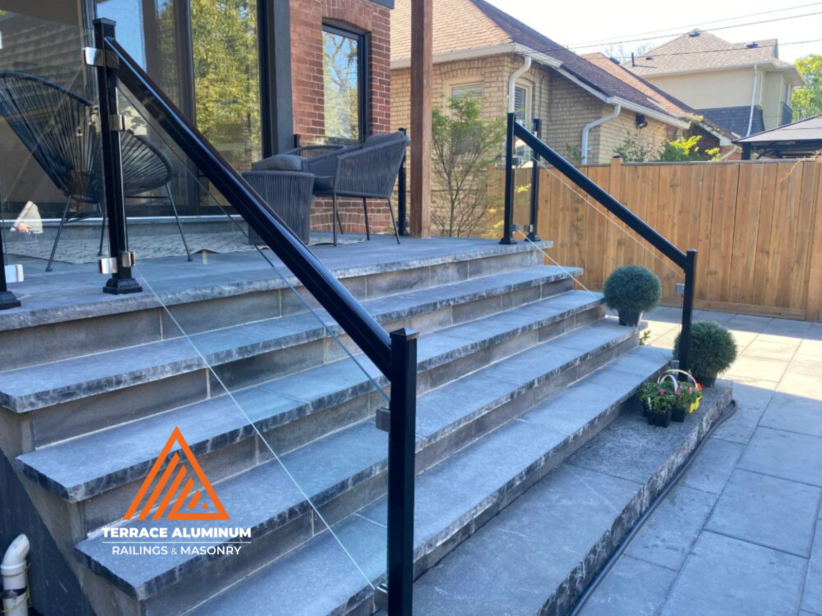 Flagstone porch in Toronto featuring frameless glass railing with aluminum posts
