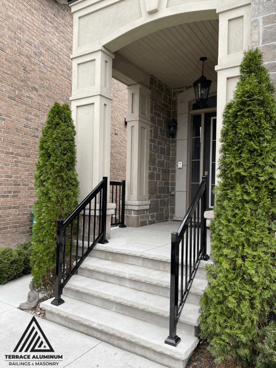 Oakville front porch with flagstone steps and black aluminum railings.