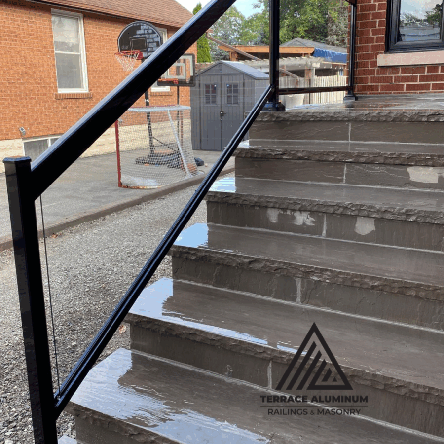 Modern Oakville patio with irregular flagstone and black glass railing