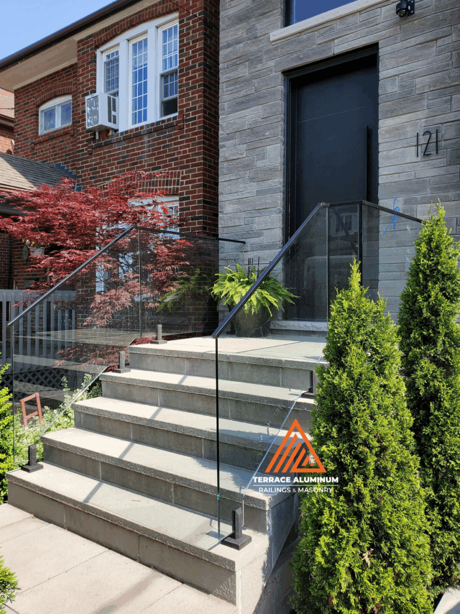 Outdoor flagstone area with clear glass railing in Oakville