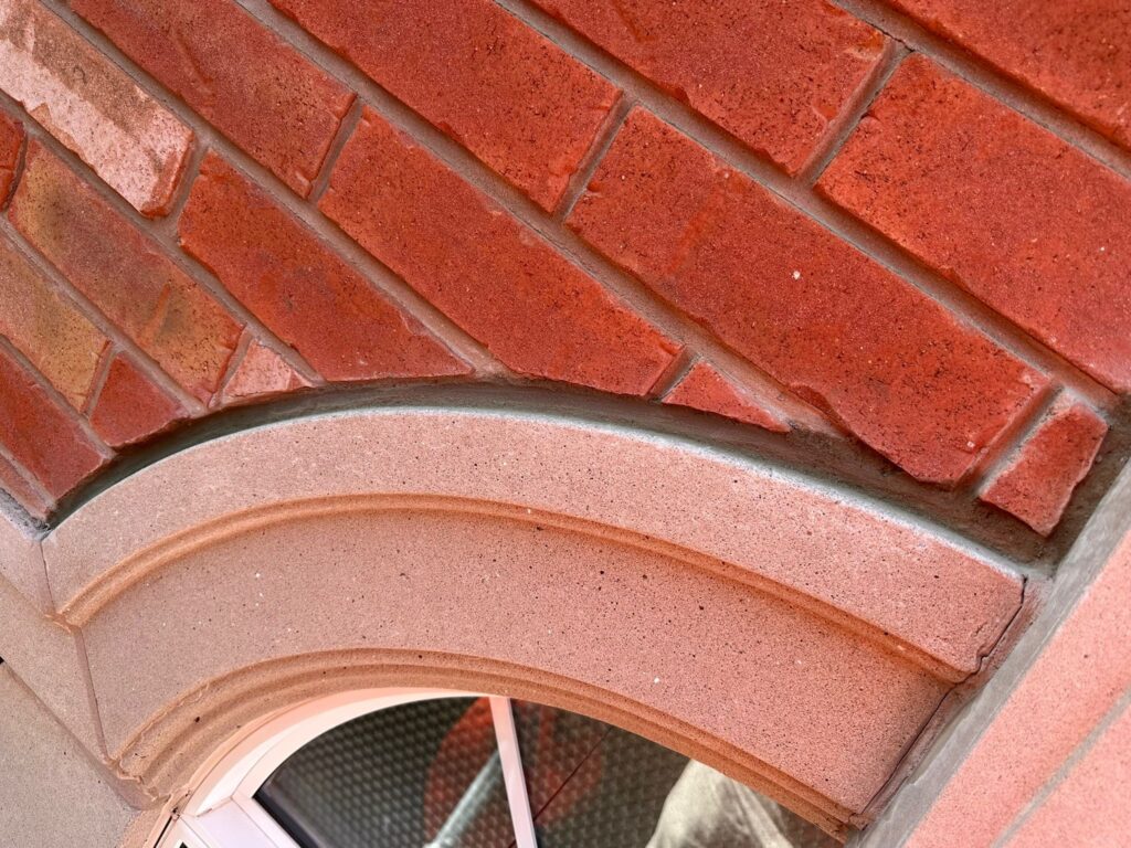 alt="Masonry repair in Hamilton with professional masons restoring brick and stone wall using precision tuckpointing techniques"