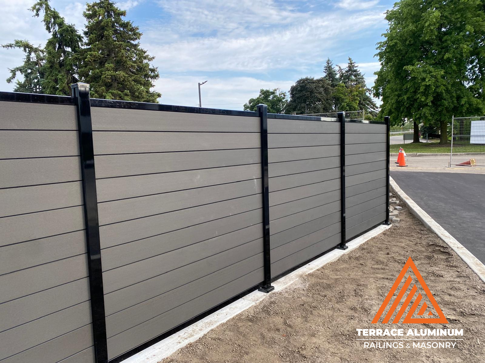 Composite fence panels with wood-grain texture and black aluminum frame