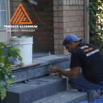 Professional masons installing flagstone porch on concrete base