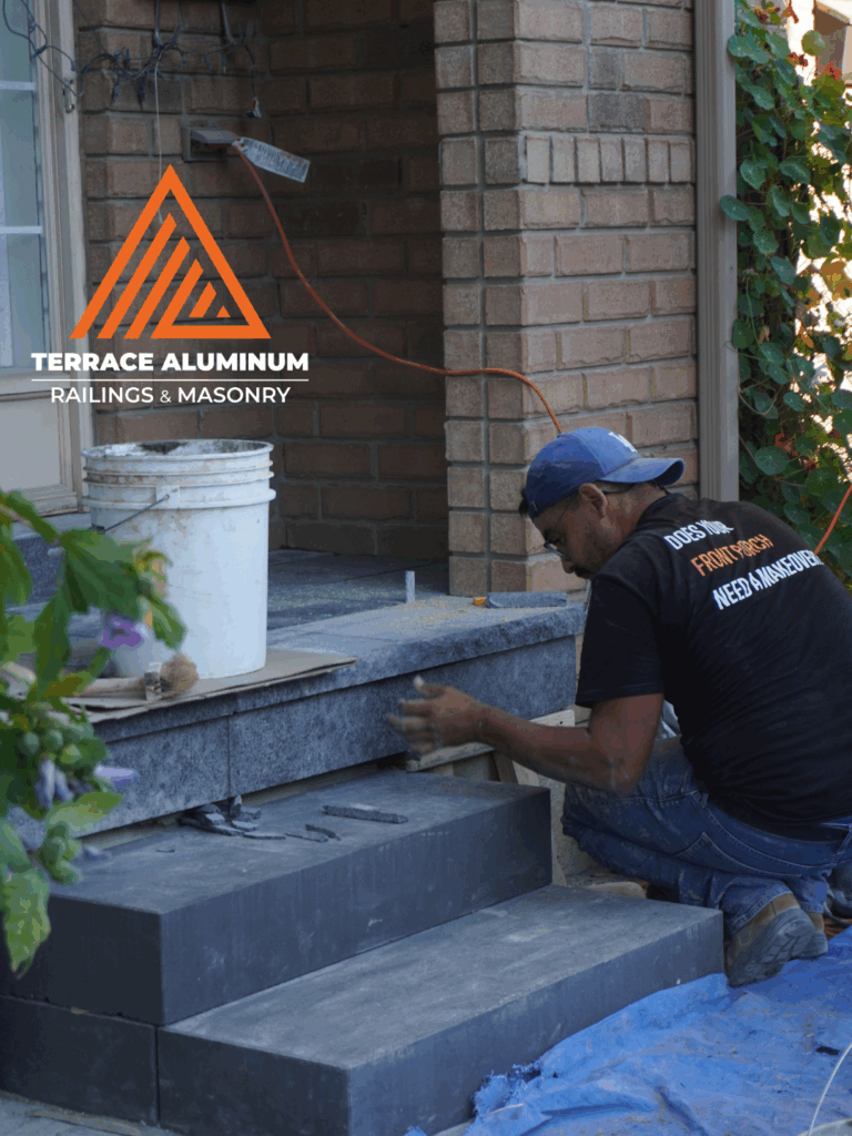 Professional masons installing flagstone porch on concrete base
