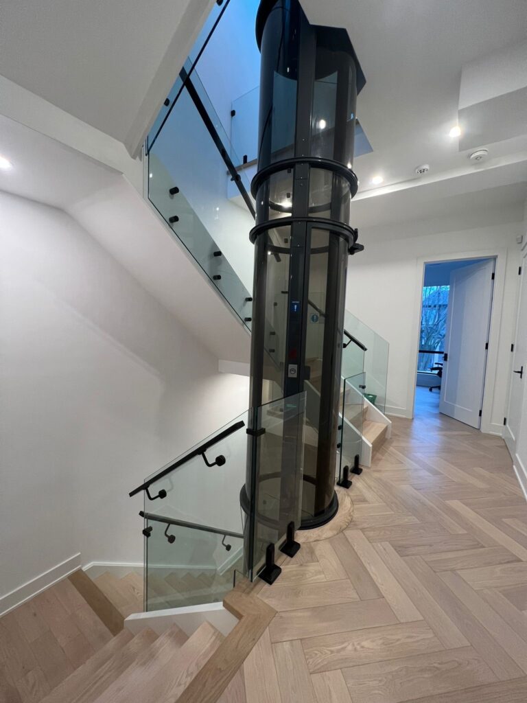 alt="Interior glass railings Toronto with frameless glass railings along a light-filled staircase in a modern home"