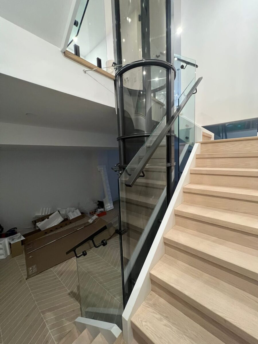 alt="Interior glass railings Toronto with frameless glass railings beside an open-concept condo staircase"