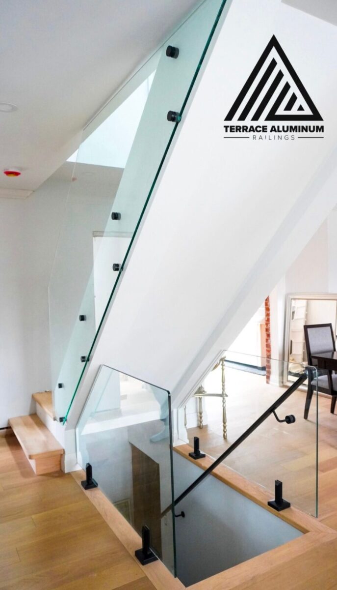Modern interior glass railing with stainless steel standoffs, spigots, and upgraded rounded glass corners in a Toronto home.