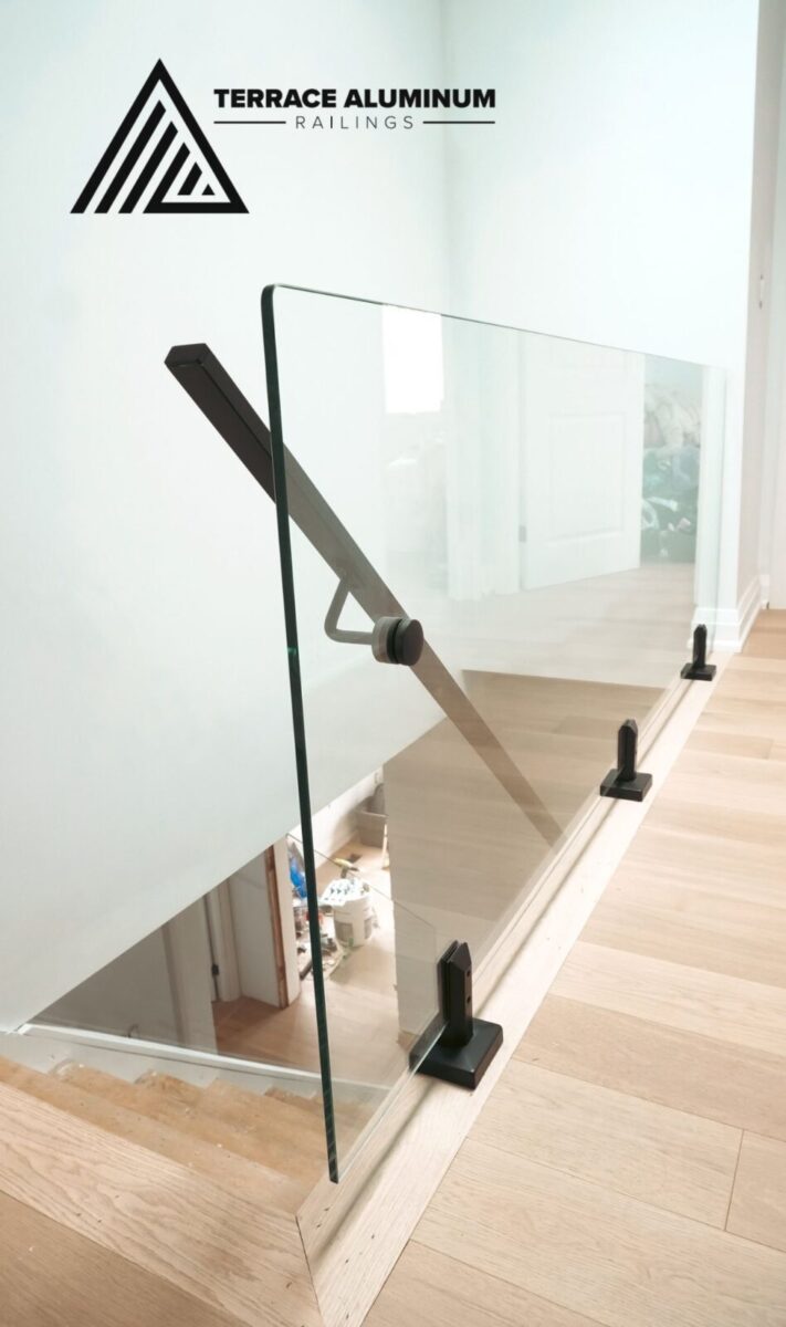 alt="Interior glass railings Toronto with frameless glass railings on a bright staircase in a modern home"