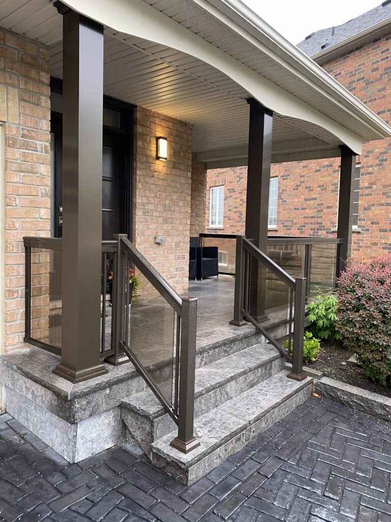 Flagstone porch with aluminum columns and frameless glass railings in Toronto.