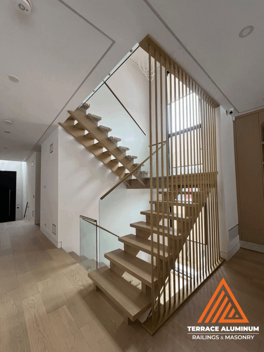 alt="Interior glass staircase handrail with clear tempered glass and stainless steel fittings in a modern Toronto home"