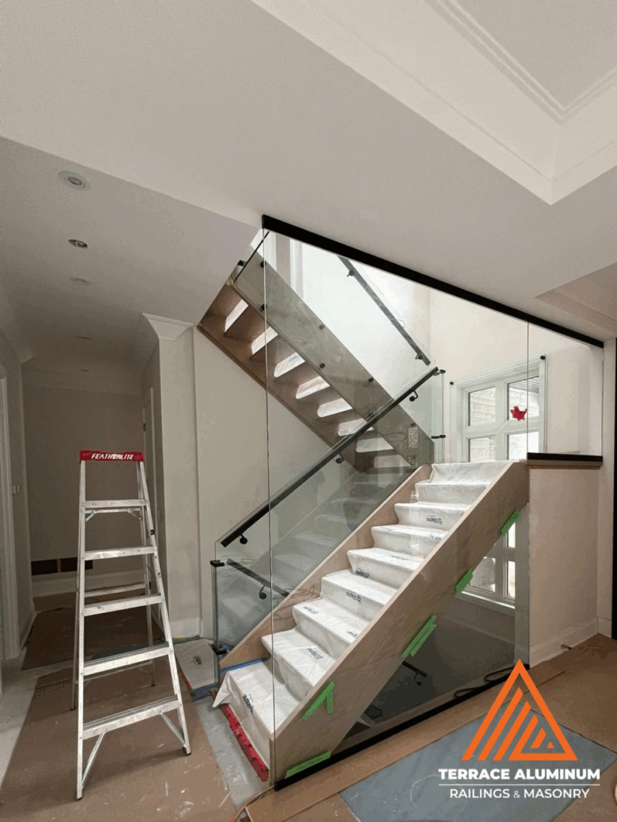 Indoor glass railing installed on upper level balcony with clear glass panels