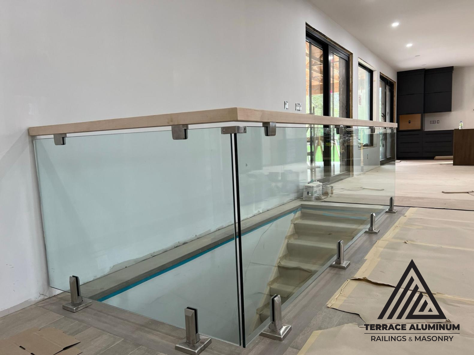 Interior glass railing system installed along mezzanine level with clear tempered panels