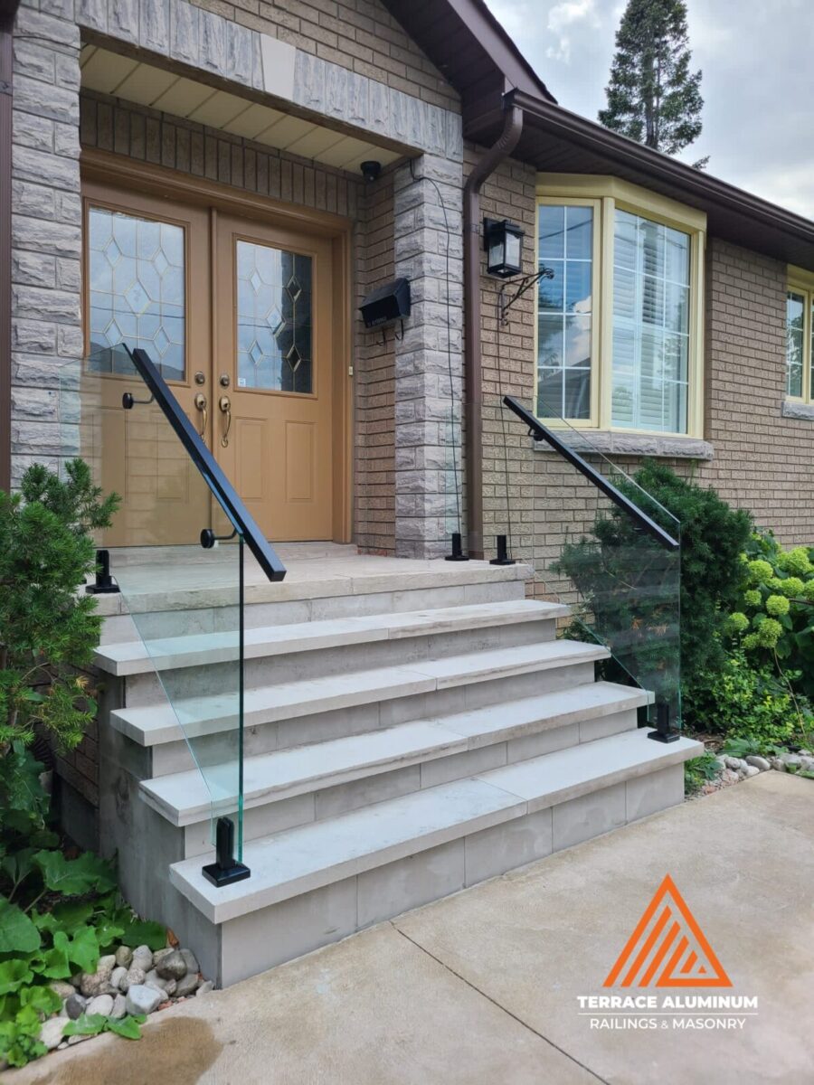 A newly built flagstone porch in Toronto featuring modern aluminum glass railings and matching aluminum columns — a perfect balance of strength, safety, and style.