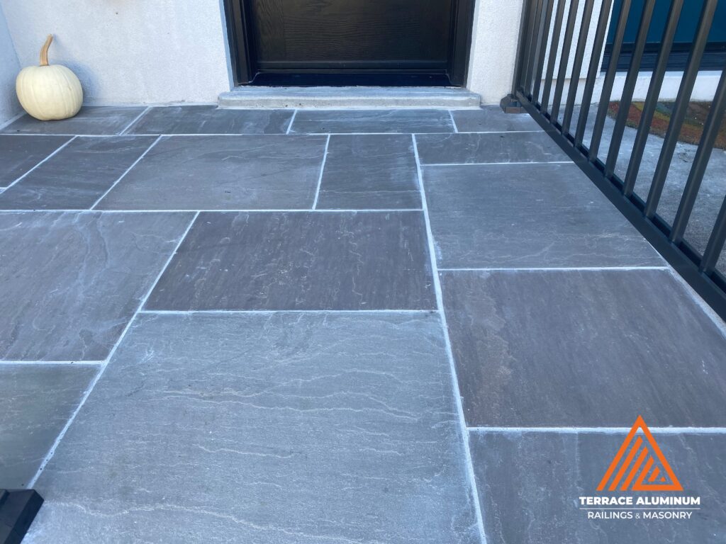 Front porch repair with flagstone in Toronto by Terrace Aluminum Railings & Masonry.