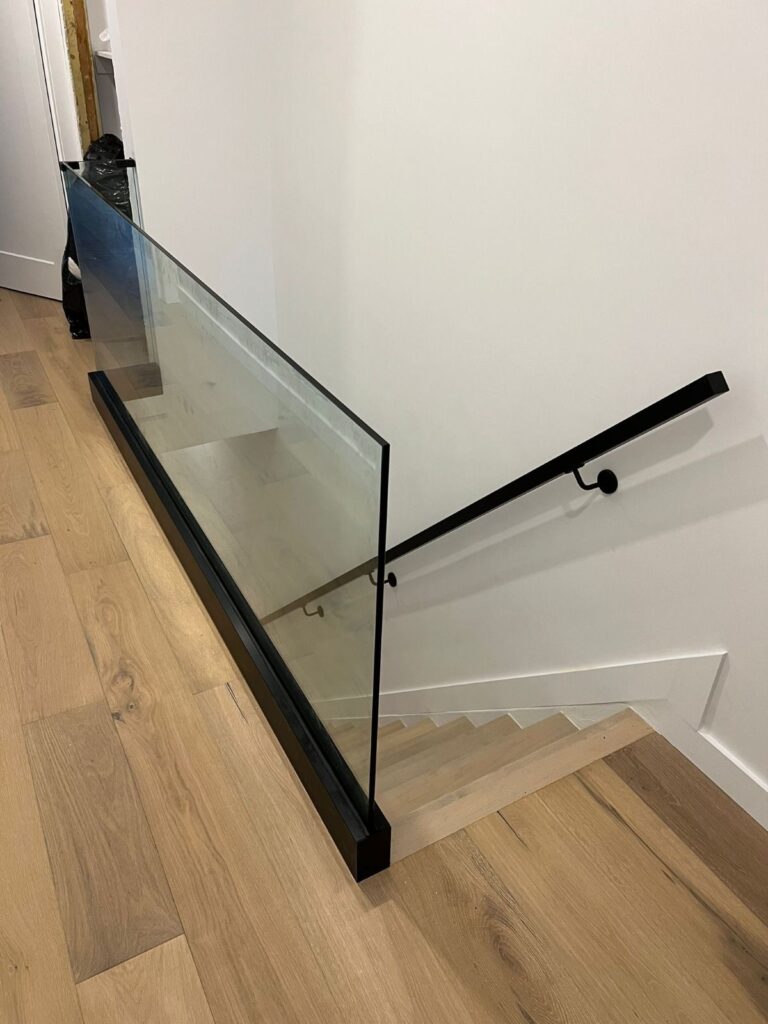 alt="Interior glass railings Toronto featuring frameless glass railings on a minimalist staircase in a modern Toronto home"
