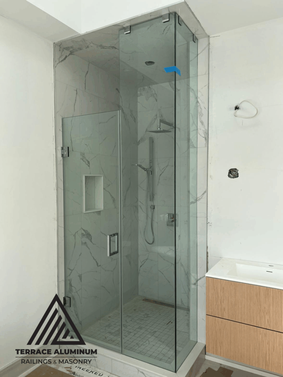 Corner frameless shower glass enclosure with chrome hardware in Toronto condo