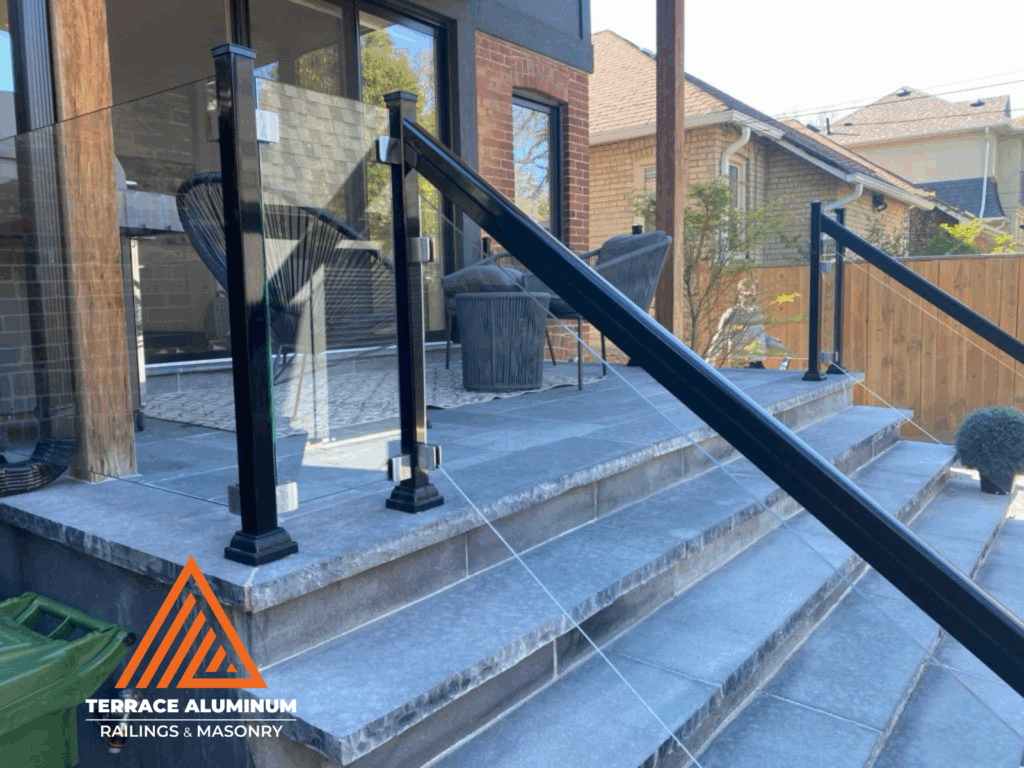 "Frameless glass railing with aluminum posts installed in Toronto by Terrace Aluminum Railings, featuring 12mm tempered glass panels for a clean and modern look."
