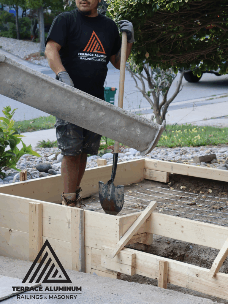Concrete contractor pouring and leveling new concrete porch base in Toronto – Terrace Aluminum Railings & Masonry.