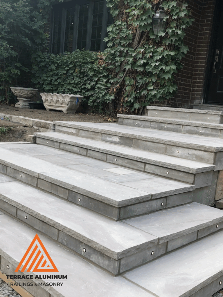 Flagstone steps on a front porch in Toronto by Terrace Aluminum Railings & Masonry.
