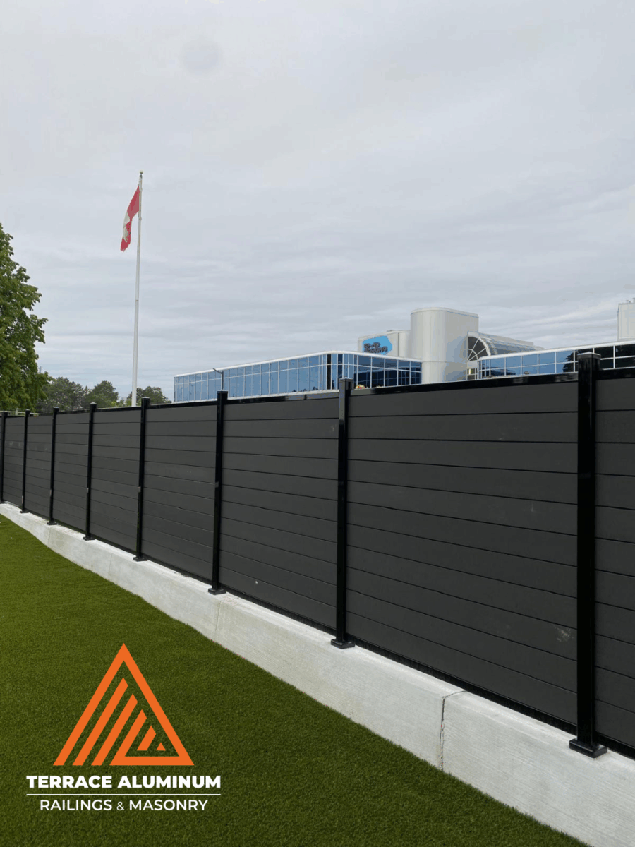 Composite wood fence with natural brown finish and aluminum framing