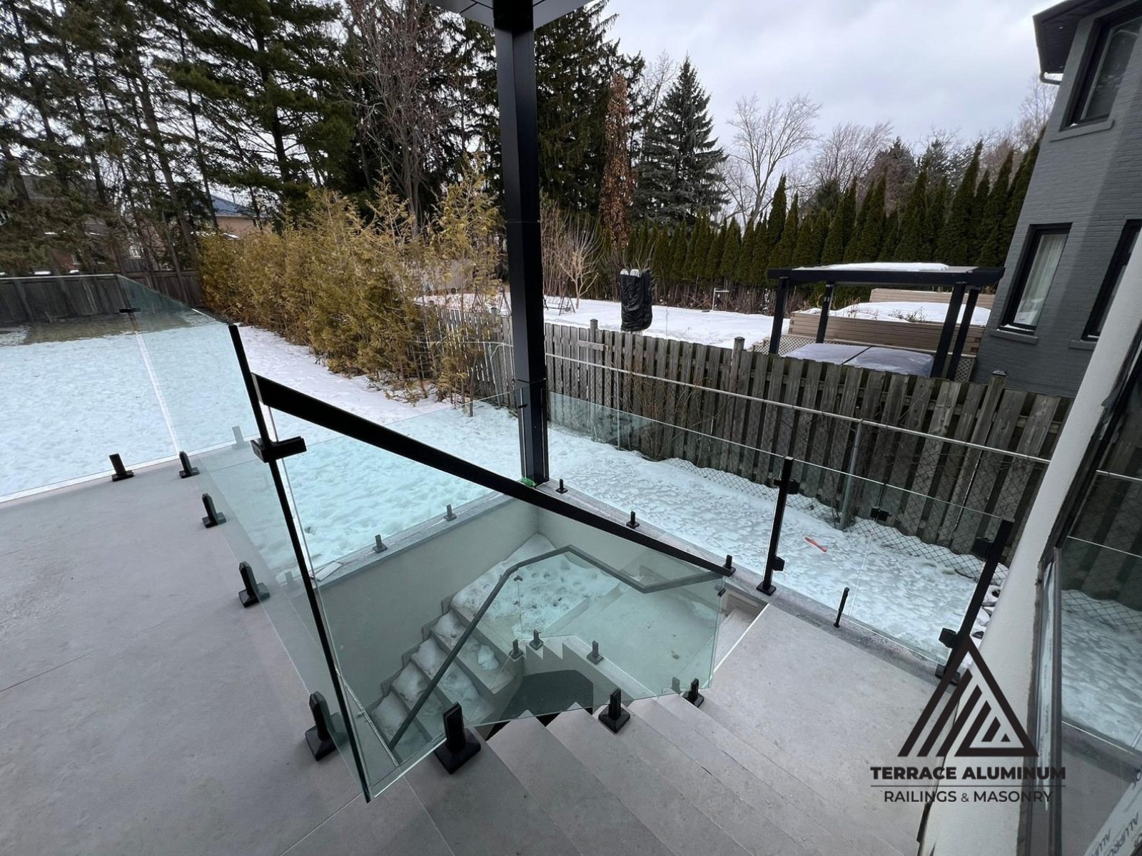 alt="Modern staircase glass handrail with tempered glass panels and stainless steel hardware installed in Toronto home"