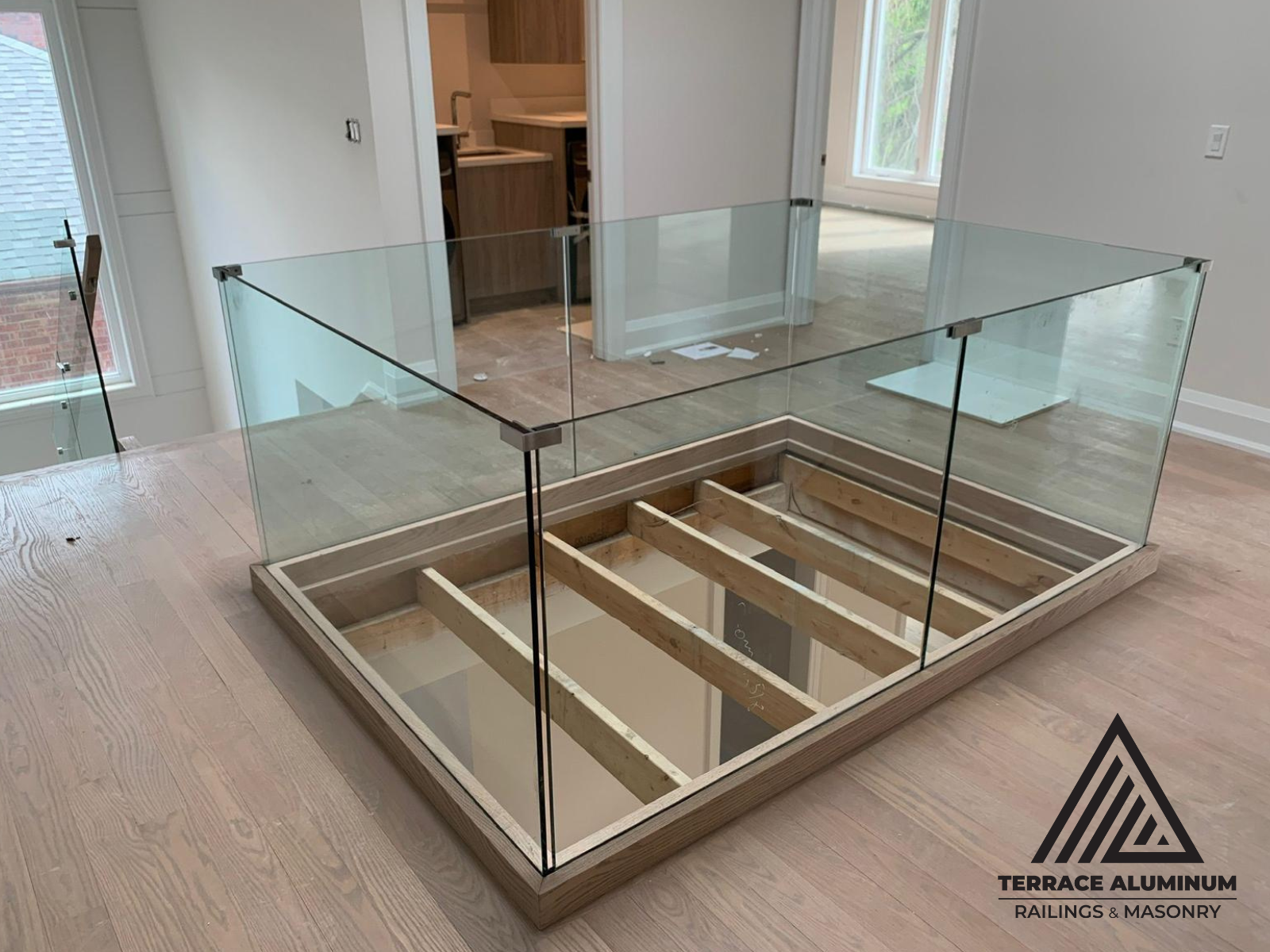 Frameless glass divider used as indoor railing separating open areas