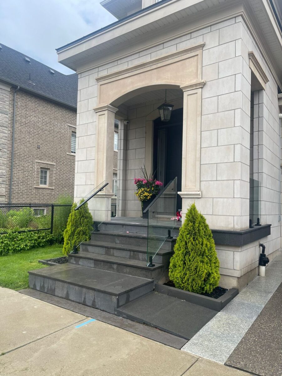 alt="Frameless glass railing on front porch designed to complement modern staircase glass handrail in Toronto"