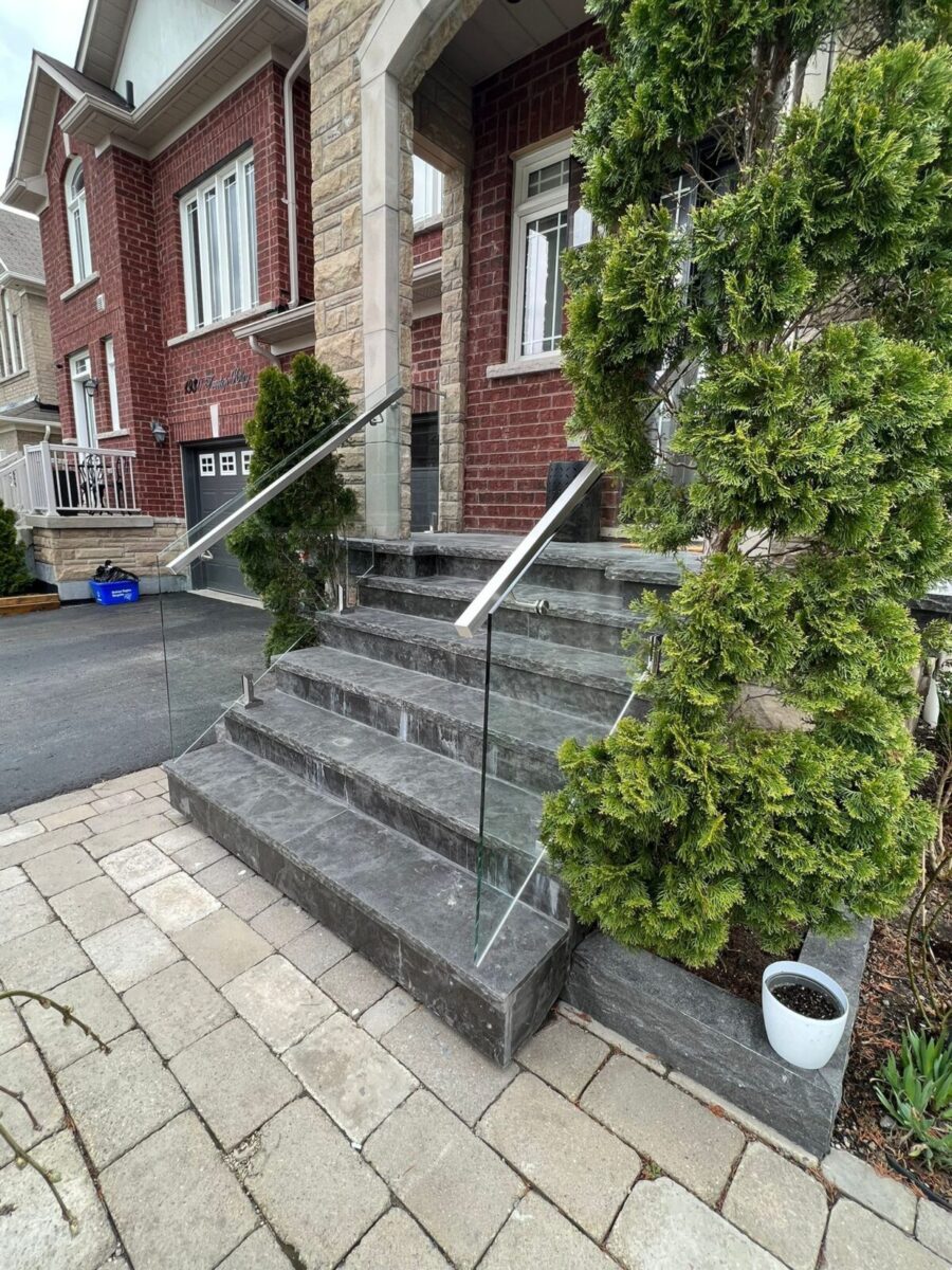 alt="Frameless glass railing installed in Toronto by Terrace Aluminum Railings, featuring 12mm tempered glass and stainless steel spigots for a sleek, modern appearance."