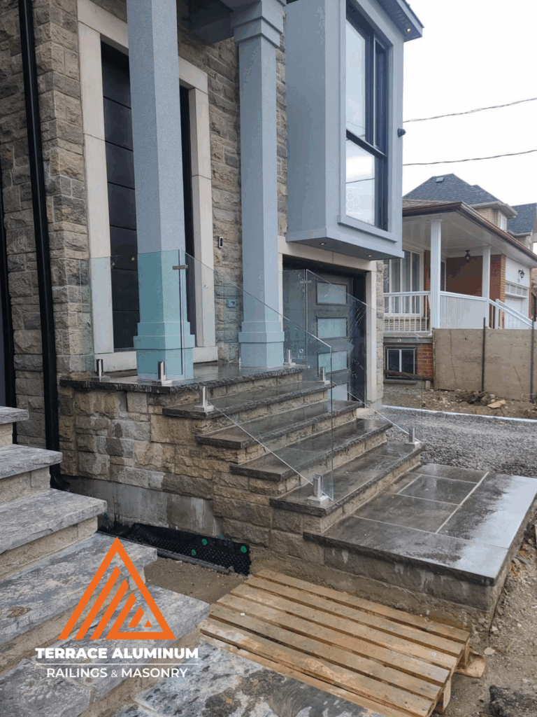 Flagstone porch with frameless glass railings in Toronto by Terrace Aluminum Railings & Masonry.