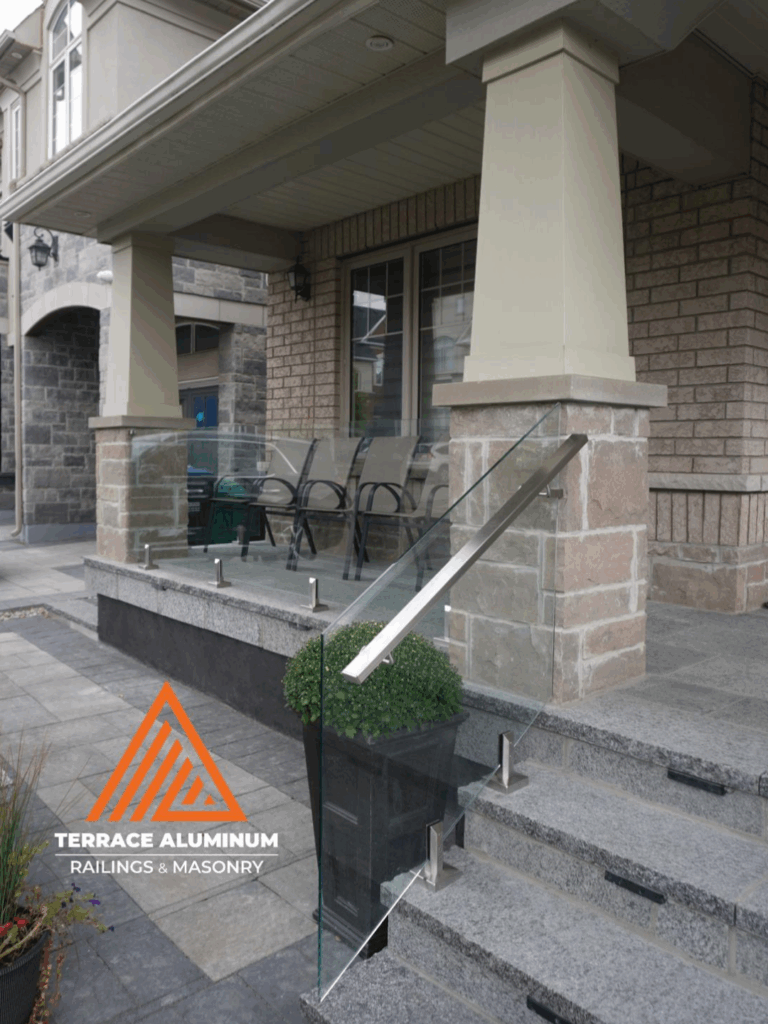 alt="Stainless steel post-mounted staircase glass handrail with clear tempered glass panels installed in Toronto"