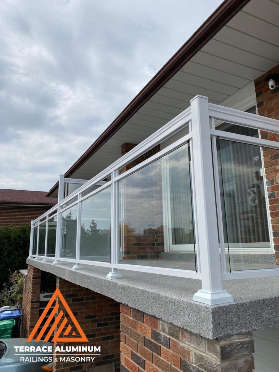 White aluminum and clear glass railings installed on a Mississauga deck by Terrace Aluminum Railings & Masonry, featuring 6mm tempered glass and powder-coated white aluminum framing.