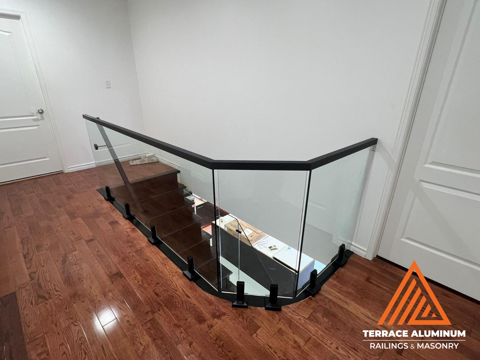 Frameless indoor glass railing with clear tempered panels in modern Toronto home