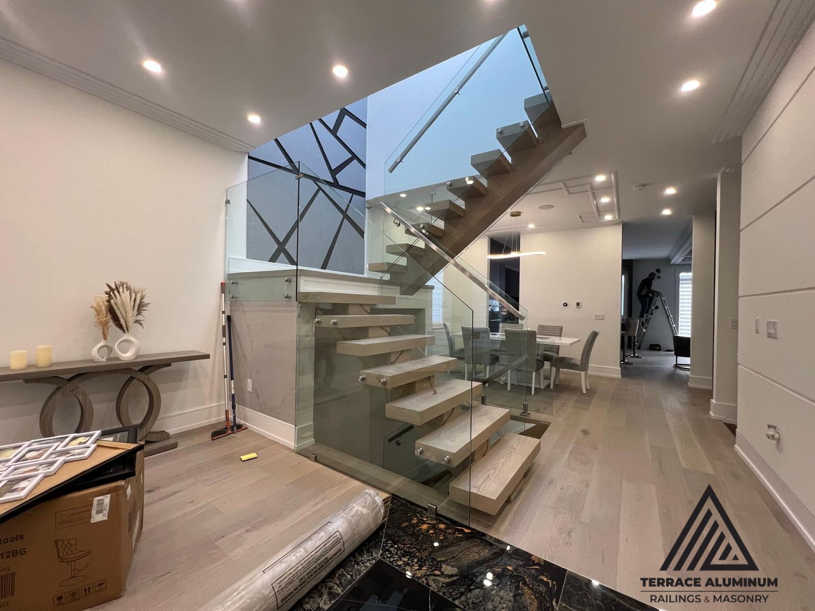 alt="Interior glass railing installed in Toronto by Terrace Aluminum Railings, featuring 12mm tempered glass panels and stainless steel hardware for a clean modern staircase design."