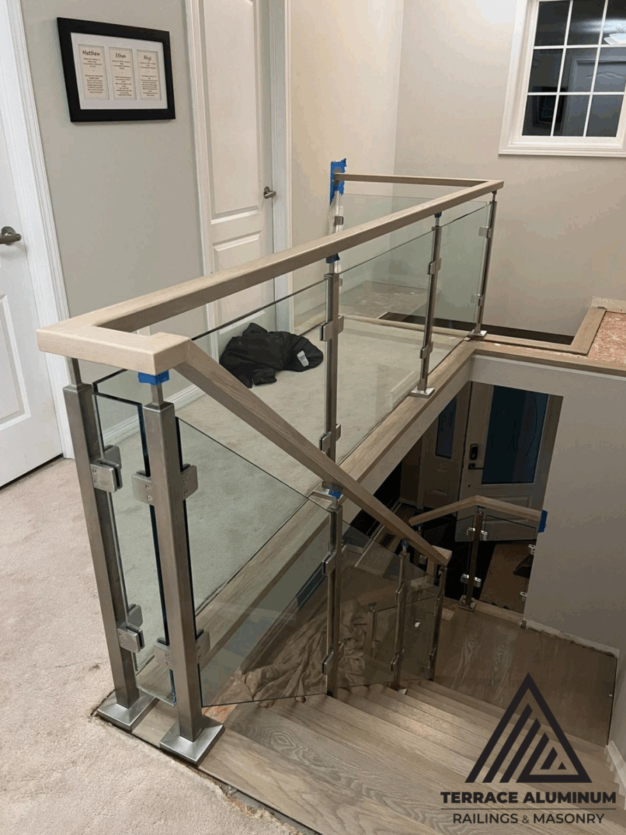 Frameless indoor glass panels forming modern interior railing system