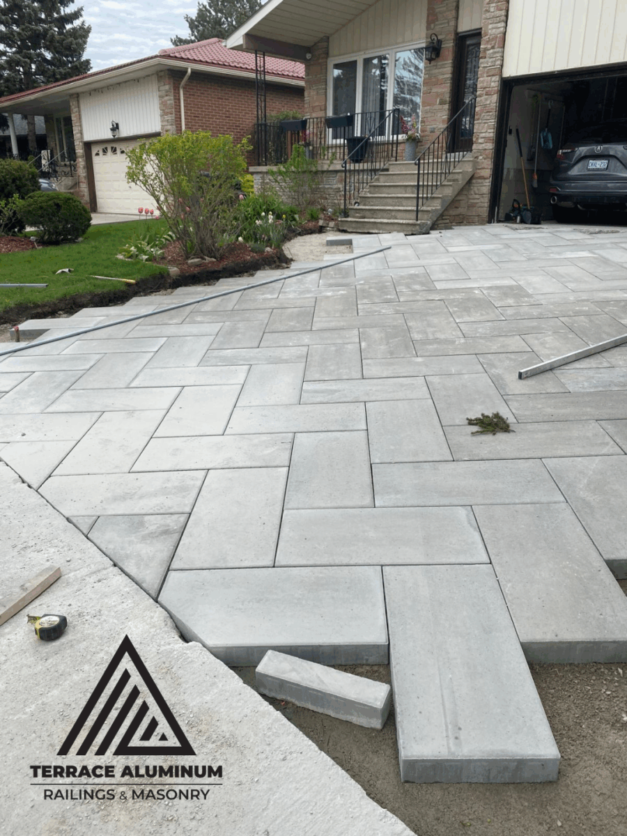 Interlock installation in progress with sand bedding and compacted base