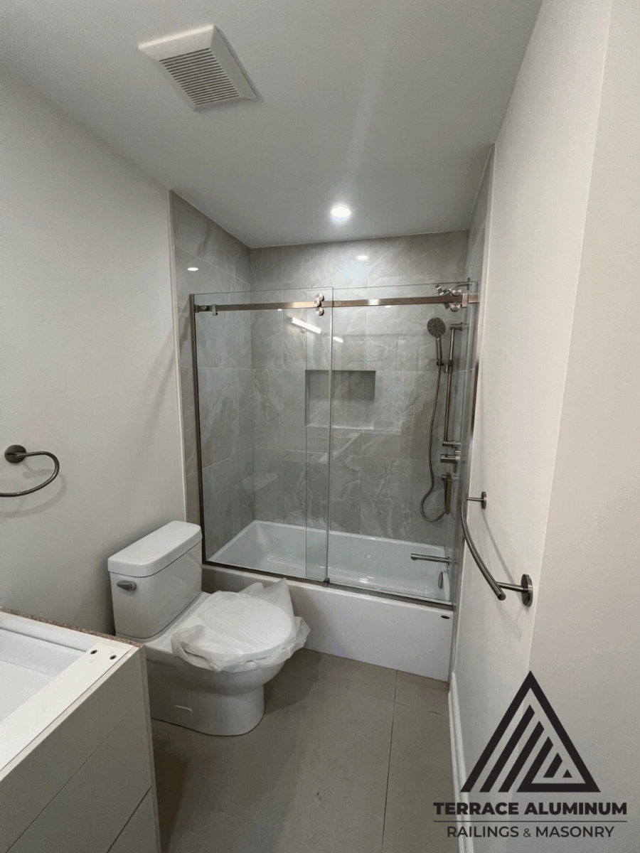 Frameless glass shower enclosure with smooth reflective finish