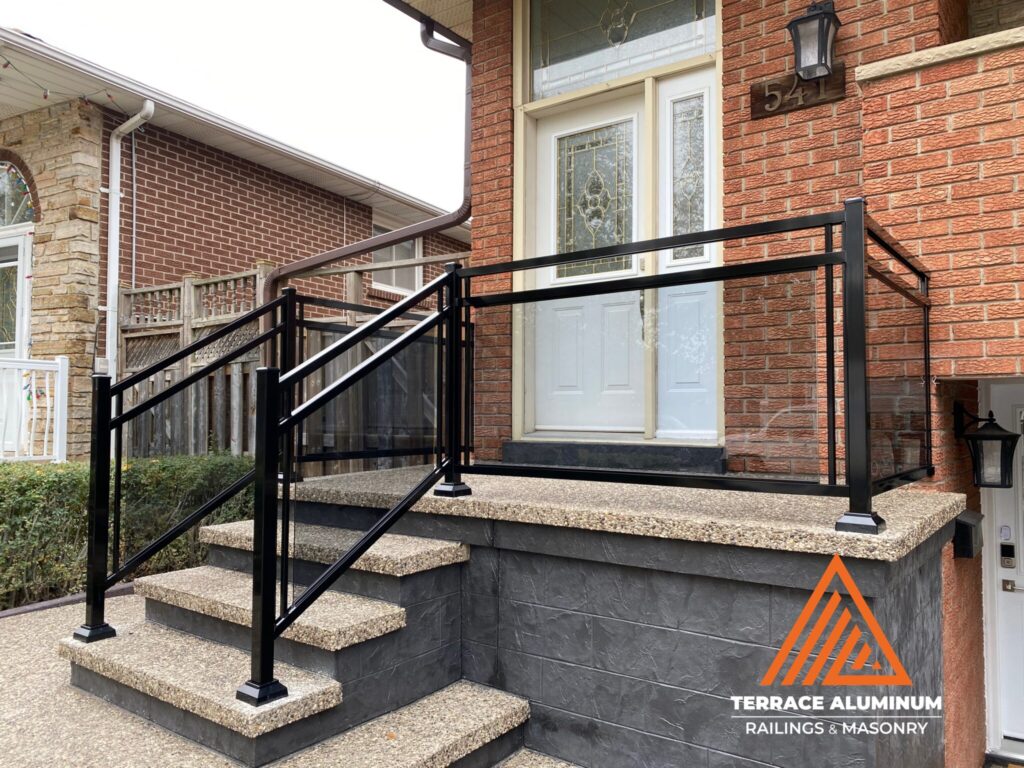 Aluminum and glass porch railing installed on a front porch in Oakville with clear tempered safety glass.