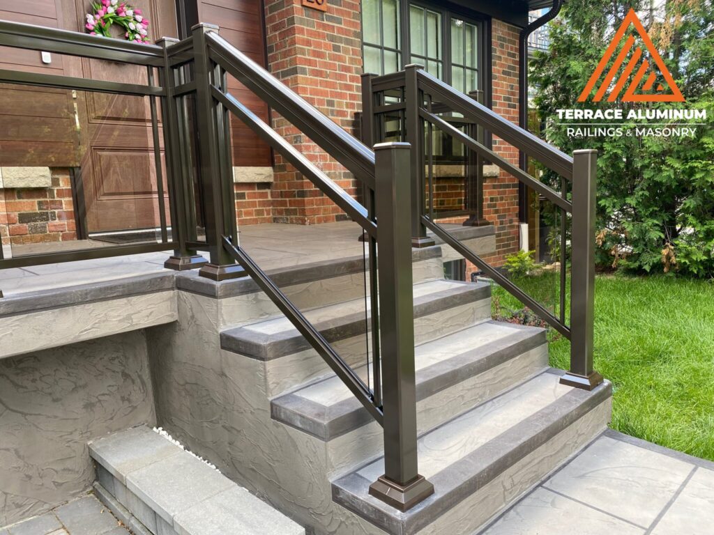 Framed aluminum and bronze-tinted glass railing installed on a front porch in Oakville