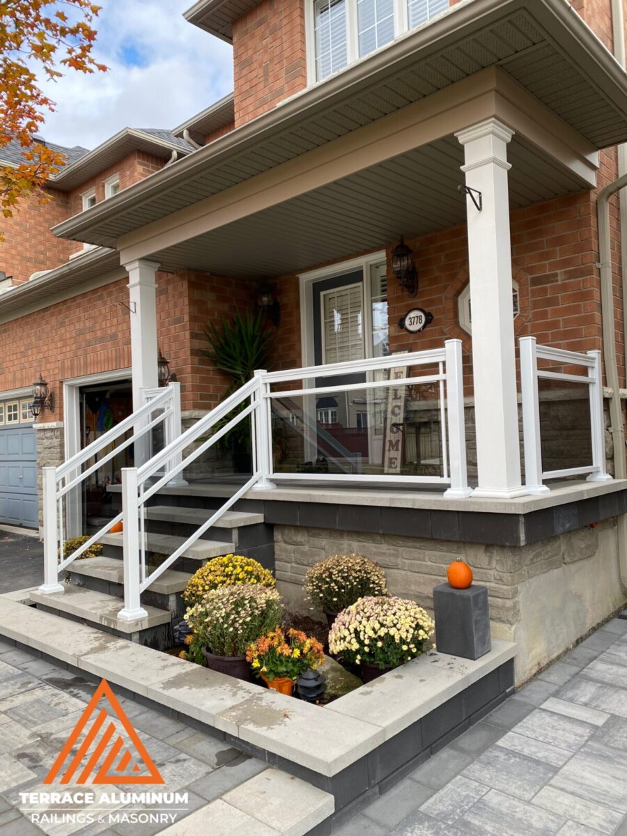 Aluminum and glass porch railing with clear tempered safety glass installed on a front porch in Oakville.