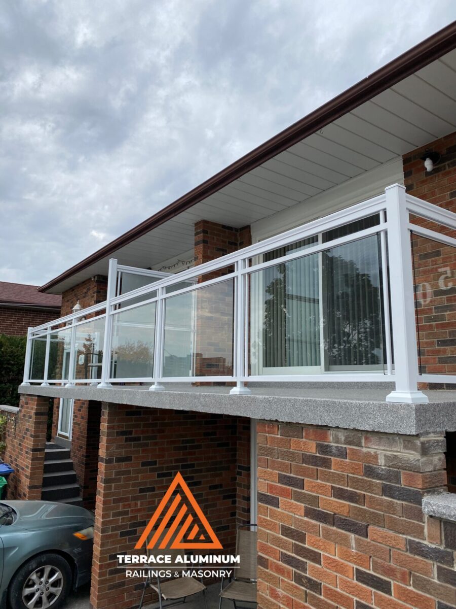 White aluminum framed glass balcony railing with clear tempered glass panels installed on a home in Oakville.