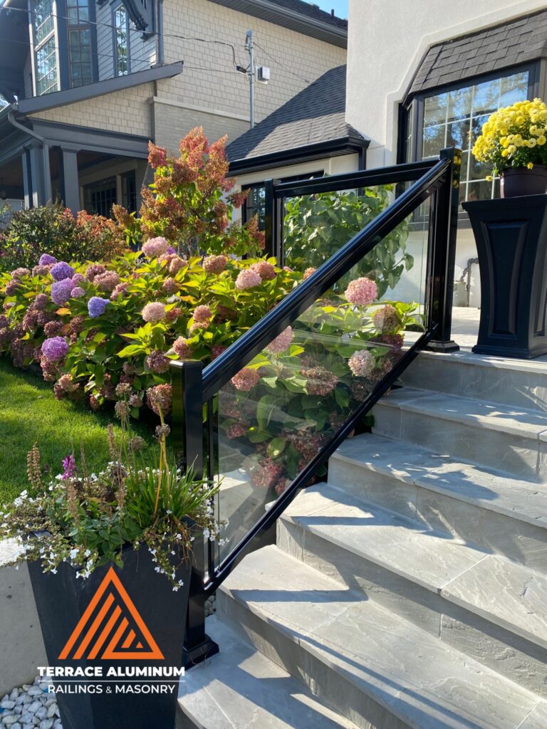 Glass front porch railing installed on a Oakville home with clear tempered safety glass panels.