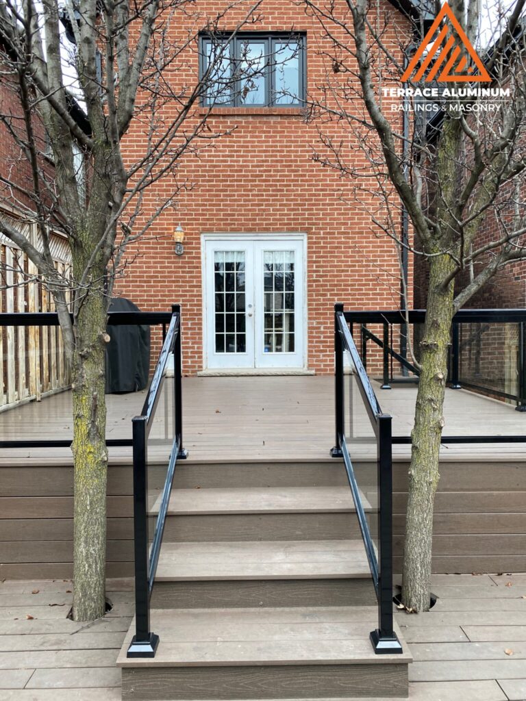 Glass deck railing installed in Oakville with clear tempered safety glass and aluminum posts. Title: