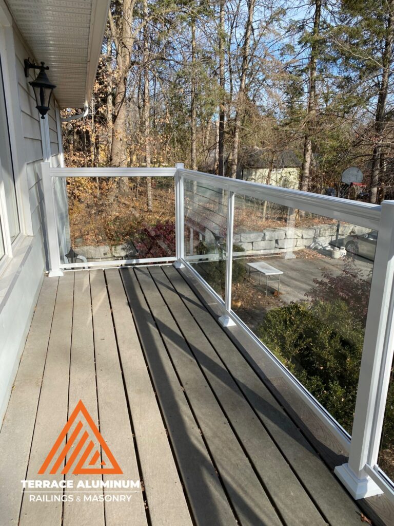 White aluminum and glass railing installed on a backyard deck in Oakville by Terrace Aluminum Railings & Masonry. Clear tempered glass panels framed in white aluminum for a bright, modern outdoor design.