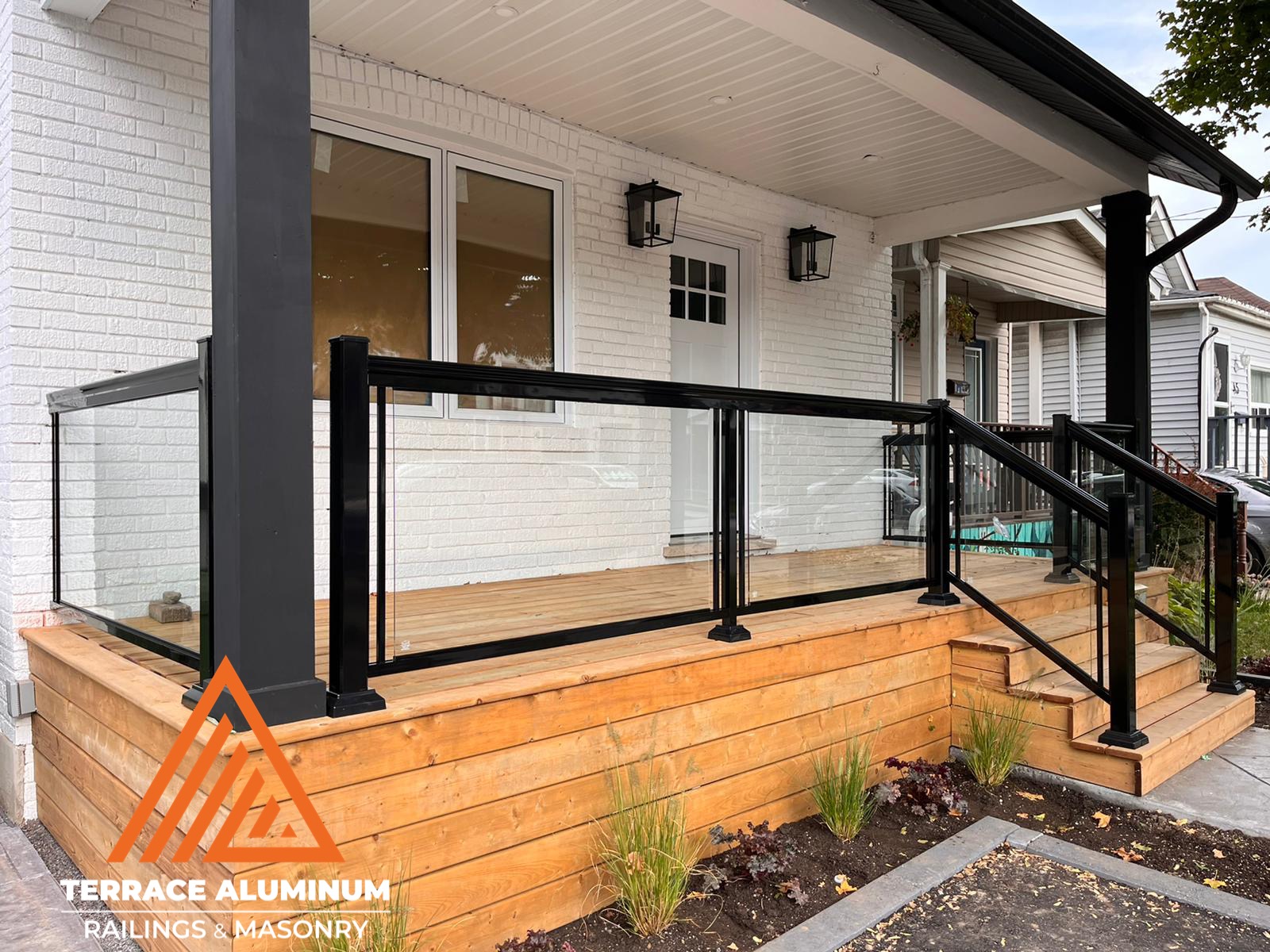 Are glass railings worth it? Aluminum and clear glass railing on a front porch featuring tempered panels and clean architectural lines