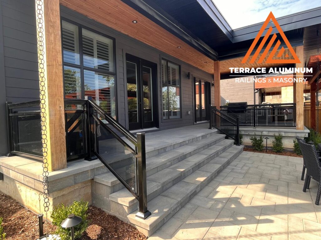 Are glass railings worth it? Framed glass railing with tinted tempered panels in a backyard deck, combining privacy and modern outdoor design